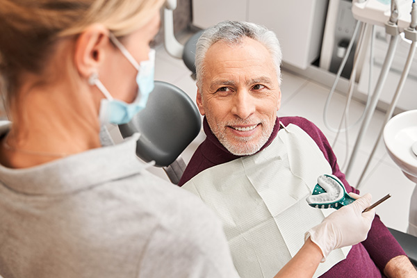 A dental professional in a modern dental office, engaged in a patient s care, with a smiling patient receiving treatment.