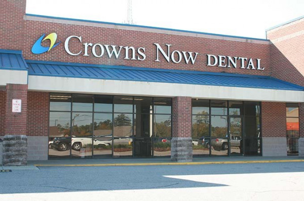 The image shows the exterior of a dental clinic named  Crowns Now Dental,  with the entrance door open, and there is a sign indicating that it s a dental clinic.