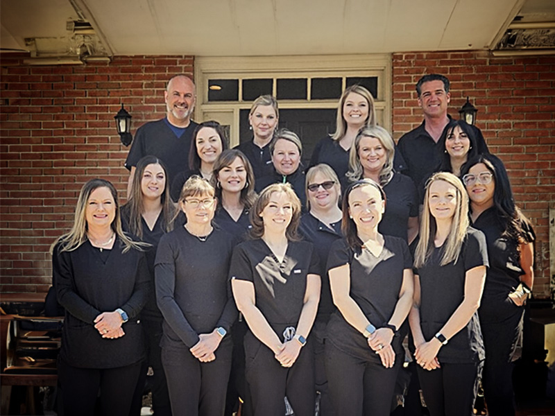 A group of people wearing scrubs, standing together outdoors.