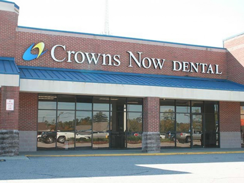 The image shows a storefront with the name  Crowns Now Dental  prominently displayed, indicating a dental practice.